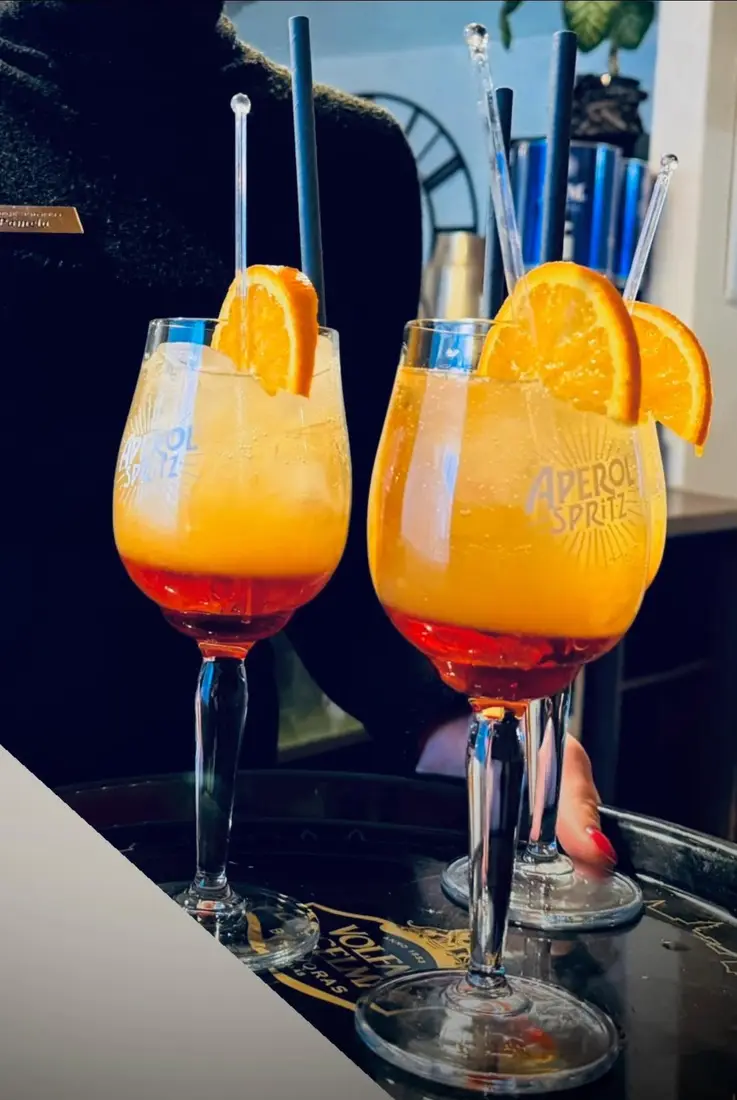 Du apelsininiai kokteiliai „Aperol Spritz“ taurėse